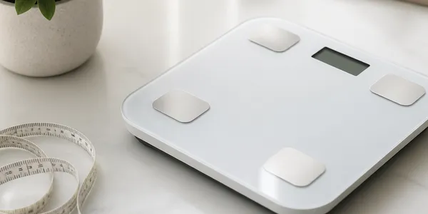 Balance et mètre ruban sur une surface claire, pour le calcul de l'IMC